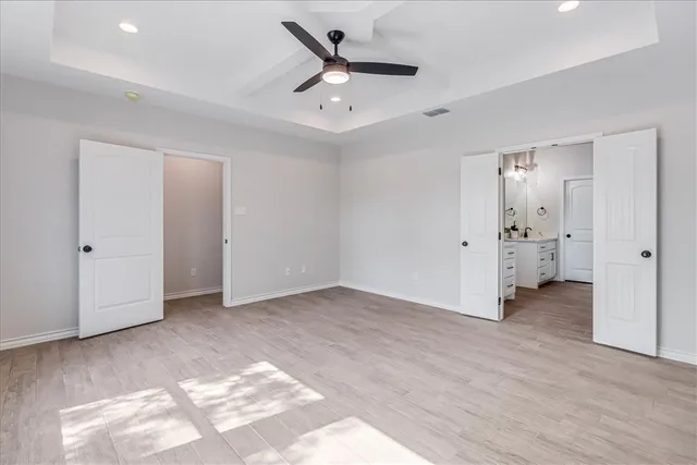 an empty room with fan and entrance