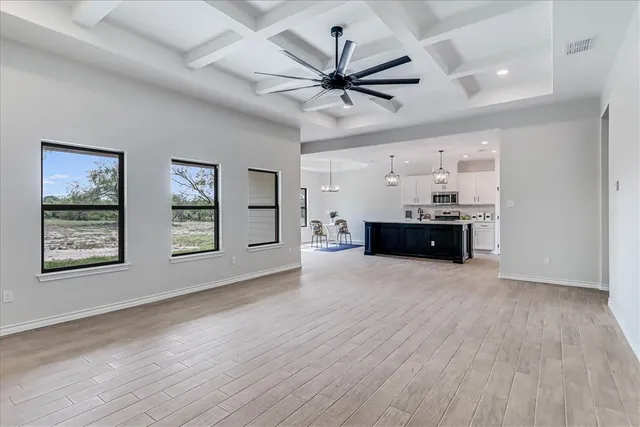 a view of a livingroom with furniture wooden floor and a ceiling fan