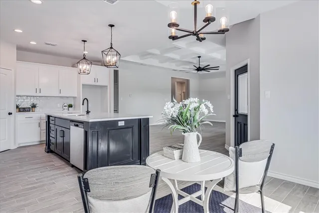 a kitchen with stainless steel appliances kitchen island granite countertop a dining table chairs and a refrigerator