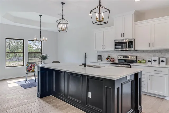 a kitchen with stainless steel appliances granite countertop a sink a stove a microwave and cabinets