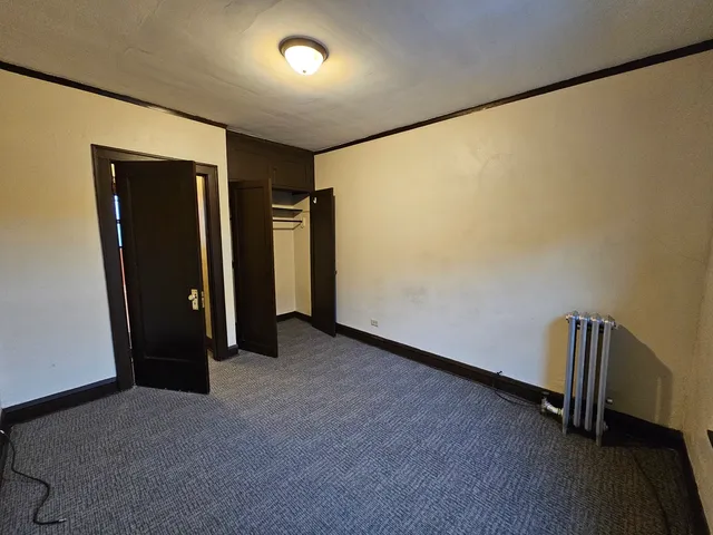 an empty room with wooden floor and closet