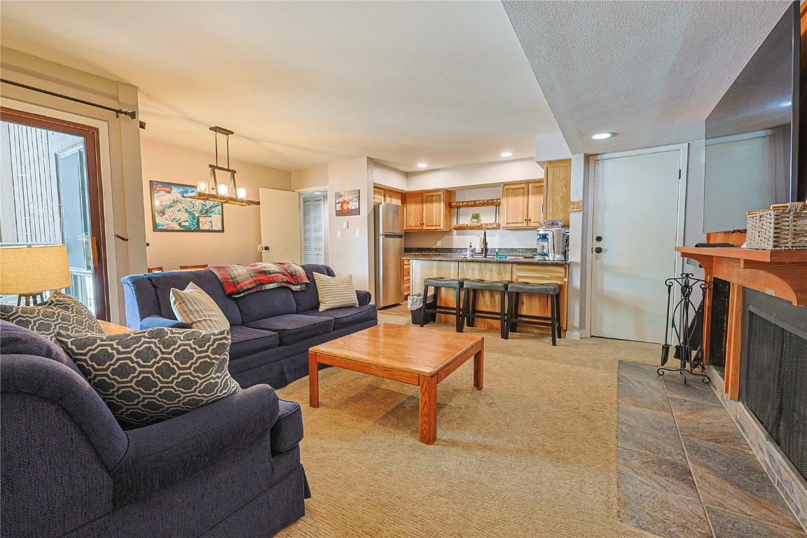 373 Wild Irishman Road, Unit 1071 Keystone, CO 80435 - Photo 2 of 22 Carpeted living area featuring a fireplace, a chandelier, and recessed lighting