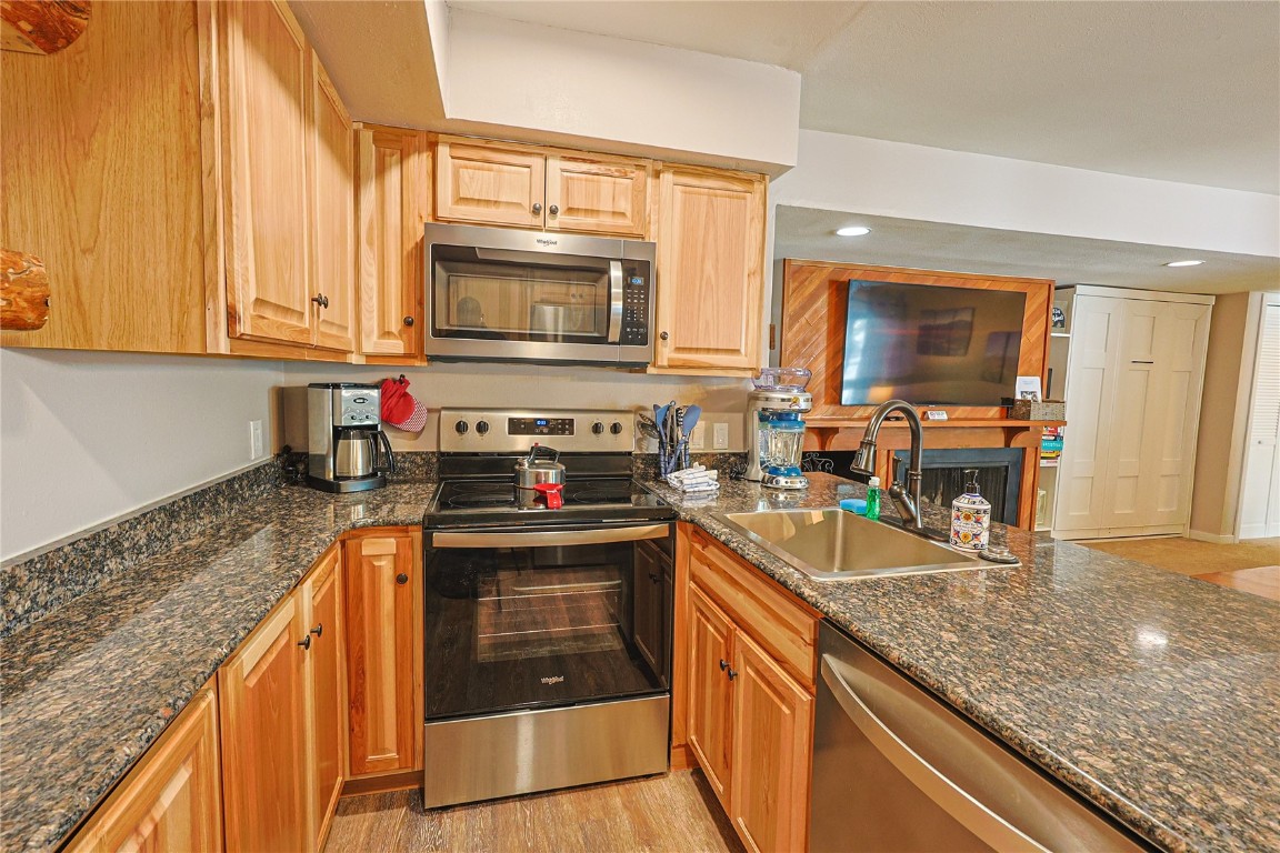 373 Wild Irishman Road, Unit 1071 Keystone, CO 80435 - Photo 7 of 22 Kitchen featuring appliances with stainless steel finishes, dark stone countertops, recessed lighting, and light wood-type flooring