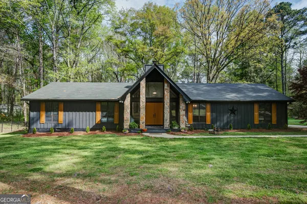 a front view of a house with a yard and trees