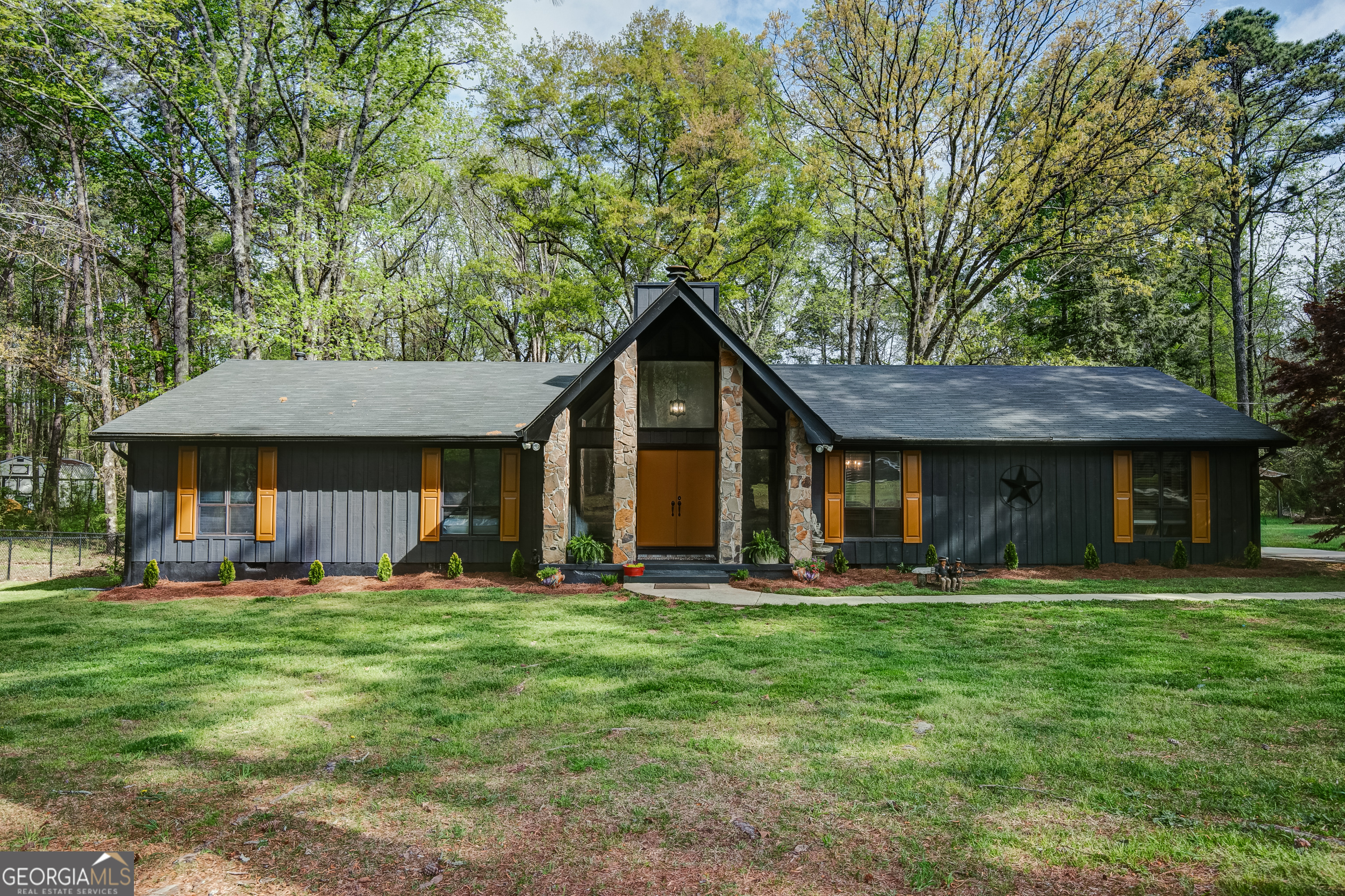 a front view of a house with a yard and trees