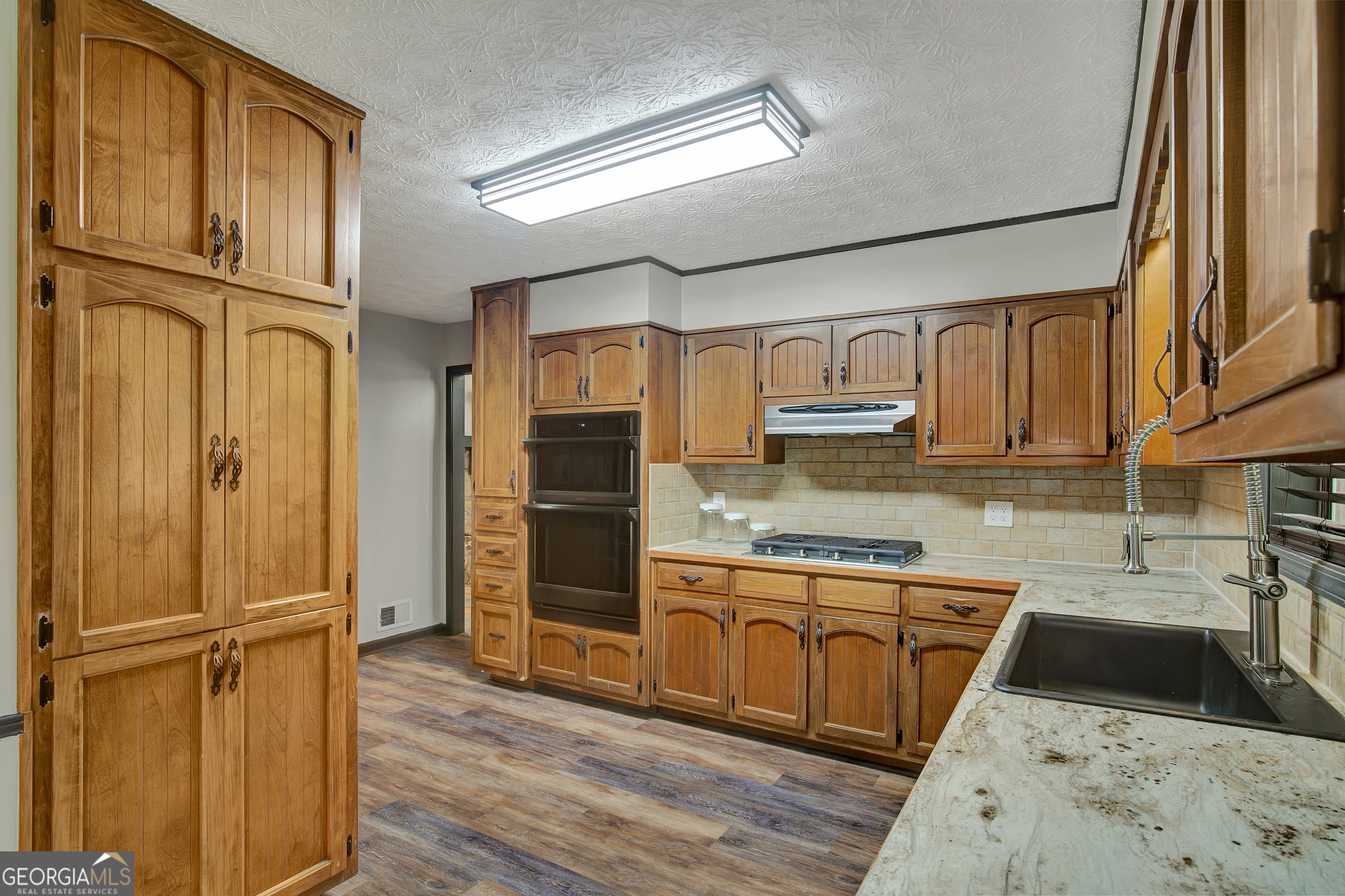 1188 Raymond Hill Road Newnan, GA 30265 - Photo 13 of 47 a kitchen with granite countertop stainless steel appliances a refrigerator a sink and cabinets