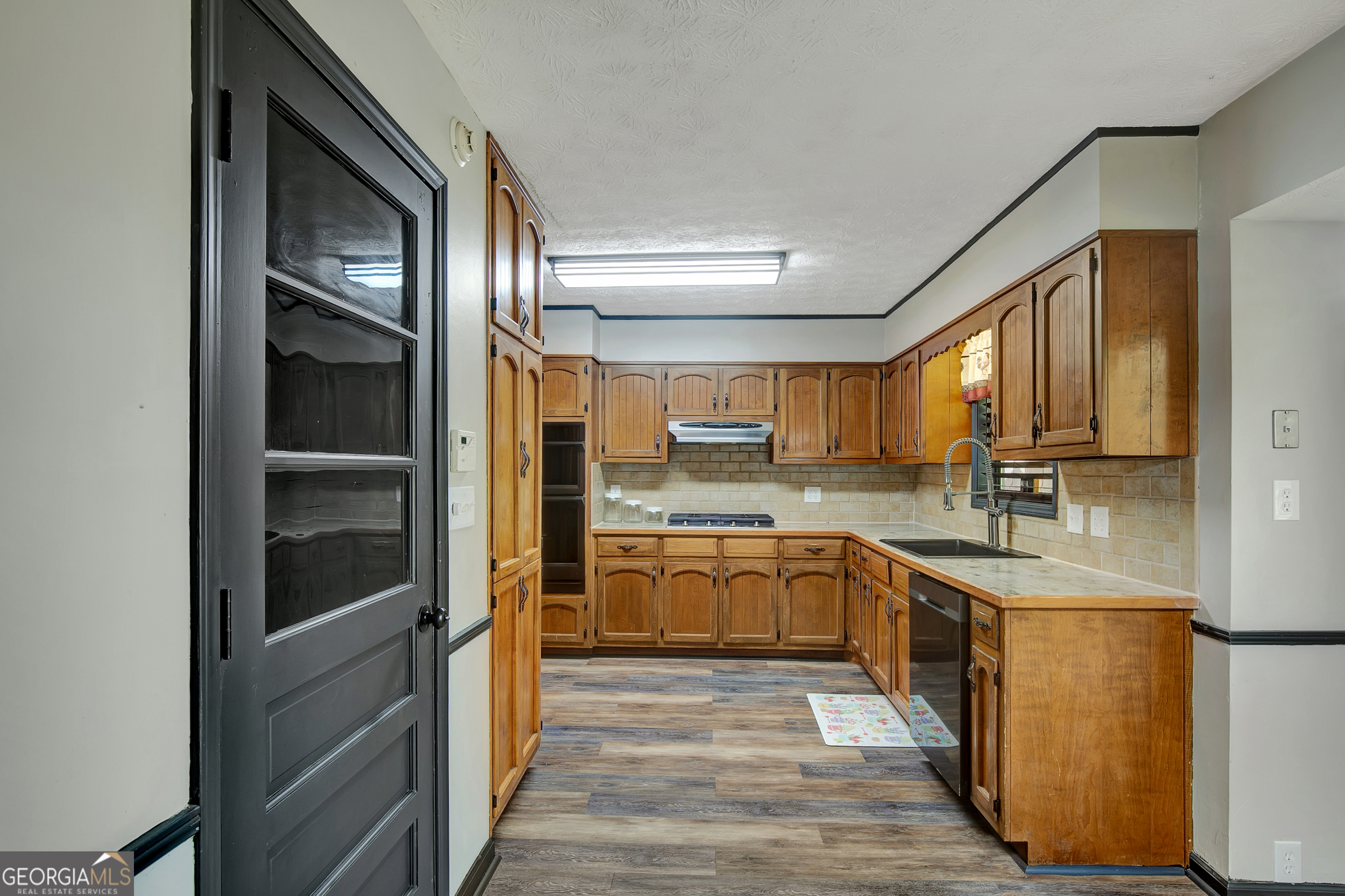 1188 Raymond Hill Road Newnan, GA 30265 - Photo 15 of 47 a kitchen with a refrigerator sink and cabinets
