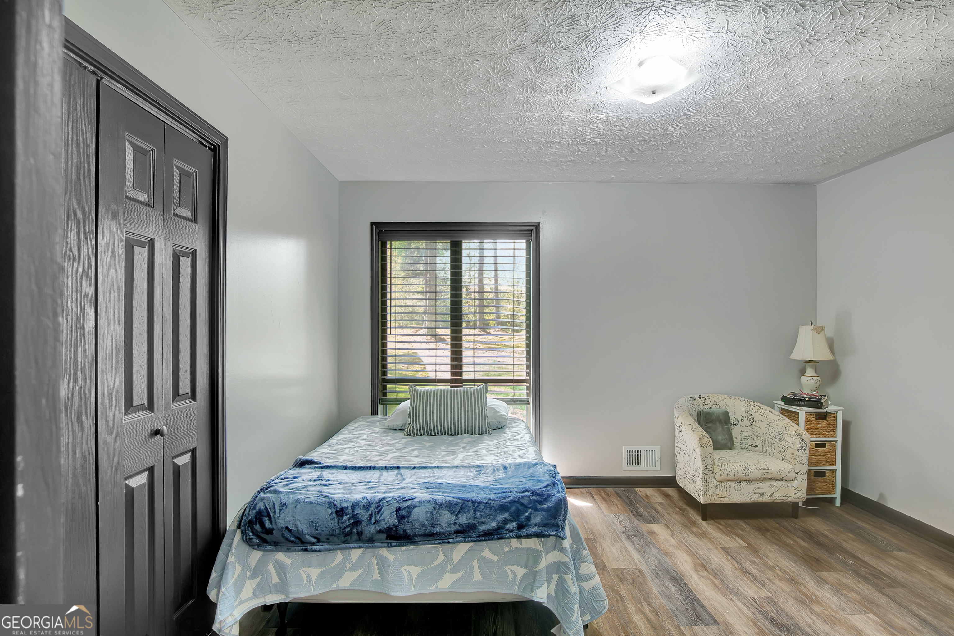 1188 Raymond Hill Road Newnan, GA 30265 - Photo 19 of 47 a bedroom with a bed and wooden floor