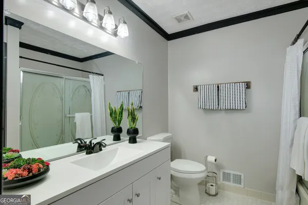 a bathroom with a toilet a sink and mirror