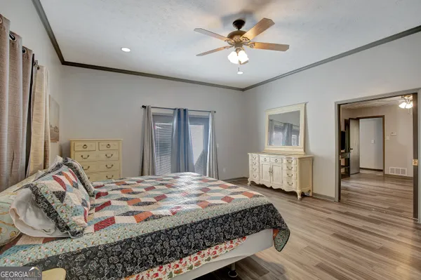 a bedroom with a large bed and a chandelier