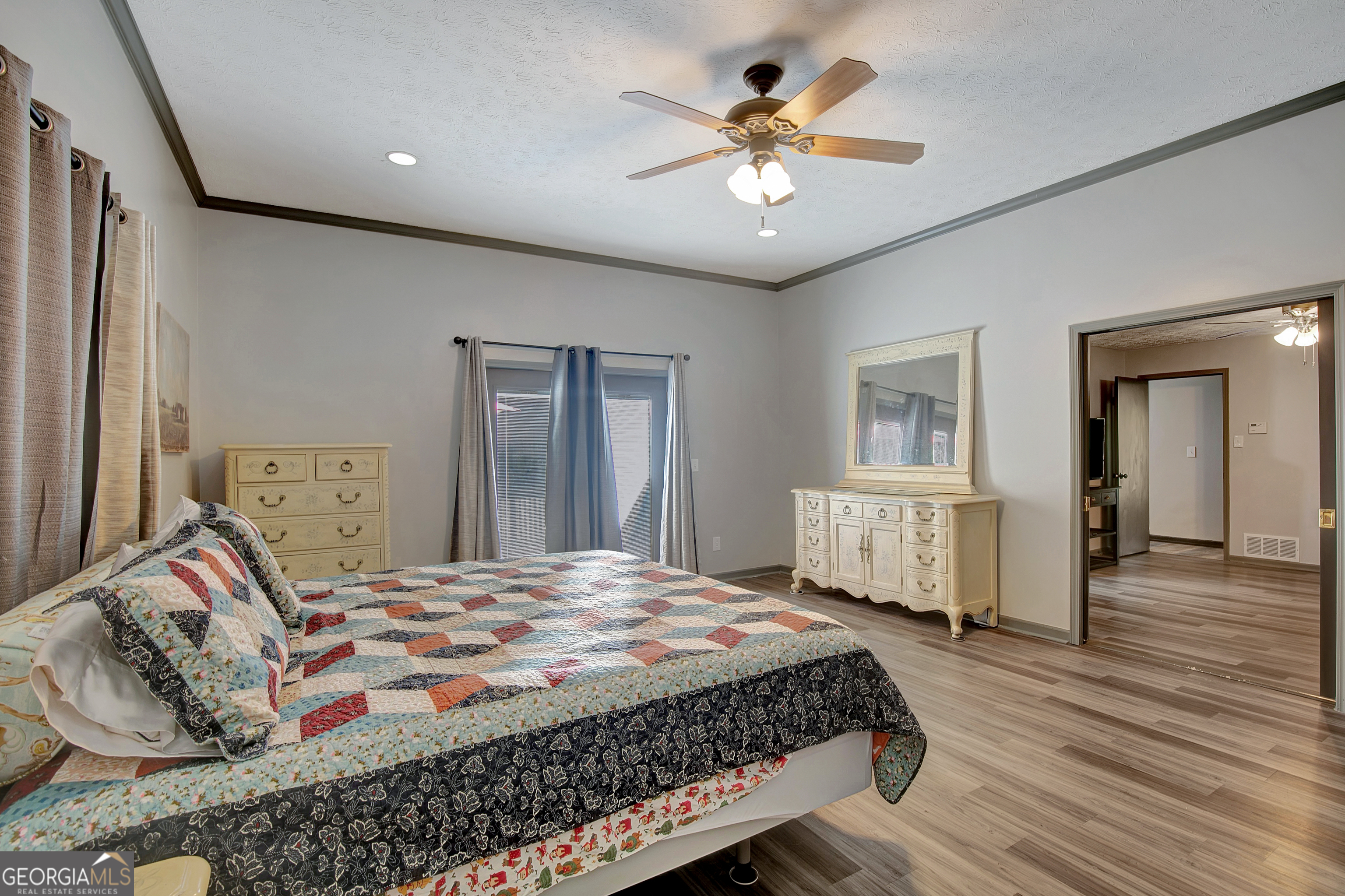1188 Raymond Hill Road Newnan, GA 30265 - Photo 26 of 47 a bedroom with a large bed and a chandelier