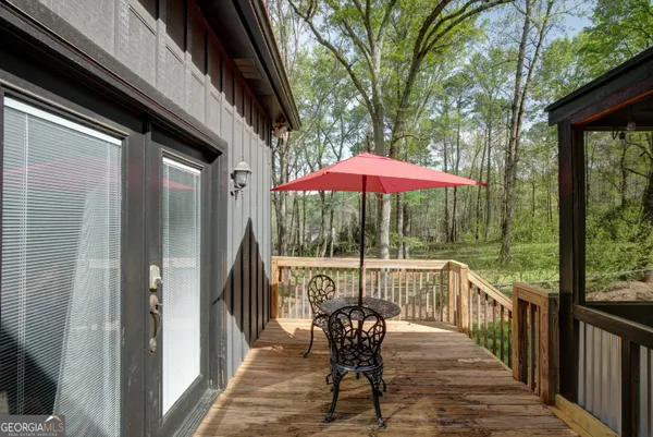 a view of a balcony with furniture and red umbrella