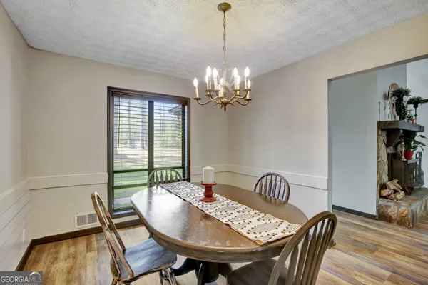 a view of a dining room with furniture wooden floor and a chandelier