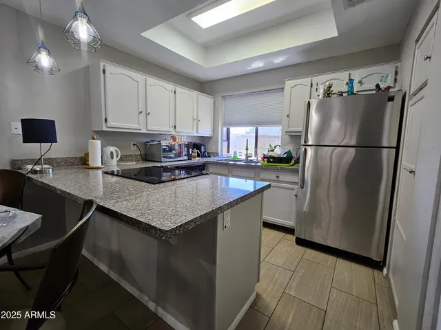 a kitchen with granite countertop a refrigerator a sink a stove a microwave and island