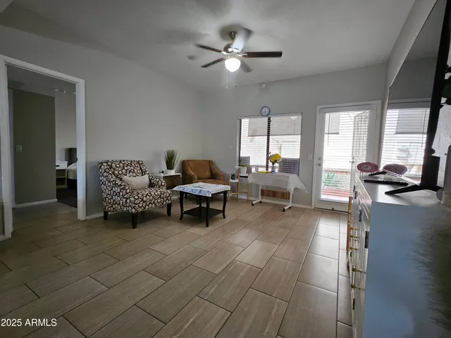 a living room with furniture and a large window with wooden floor