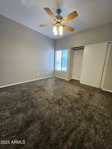 an empty room with windows and fan