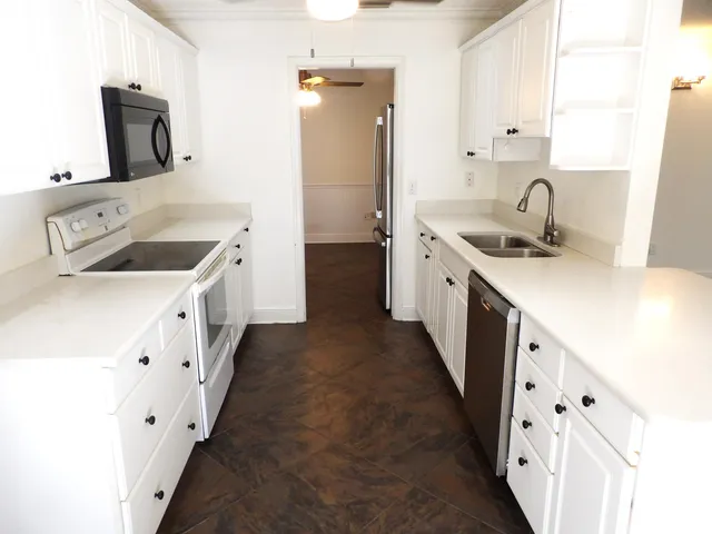 a kitchen with cabinets a sink a stove and a refrigerator