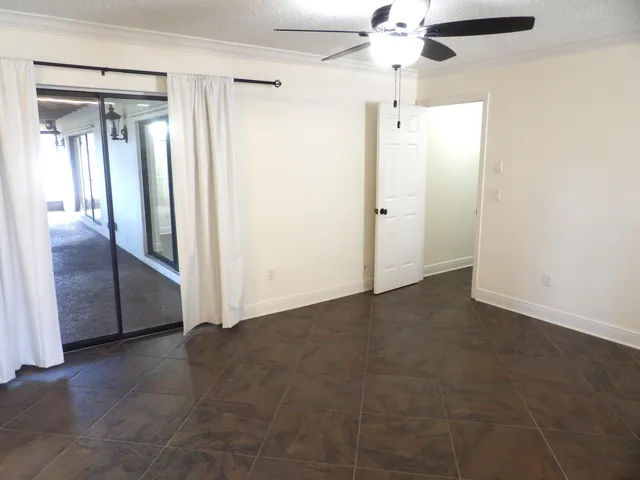an empty room with fan and entrance