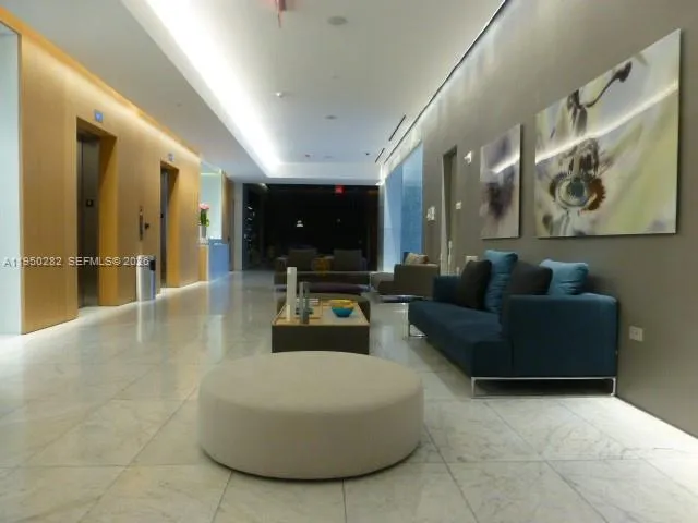 a living room with couches and kitchen view with wooden floor