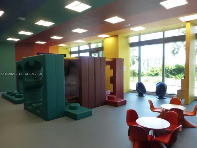 a dinning room with furniture and a large window