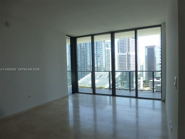 88 Southwest 7th Street, Unit 2203 Miami, FL 33130 - Photo 6 of 37 a view of an empty room with wooden floor and a window