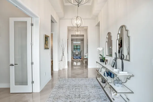 a kitchen with stainless steel appliances kitchen island granite countertop a refrigerator a sink dishwasher a oven with white cabinets and wooden floor