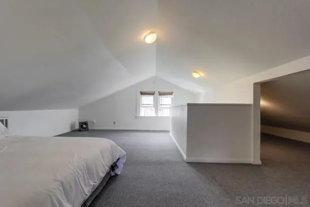 a spacious bedroom with a bed and a lamp