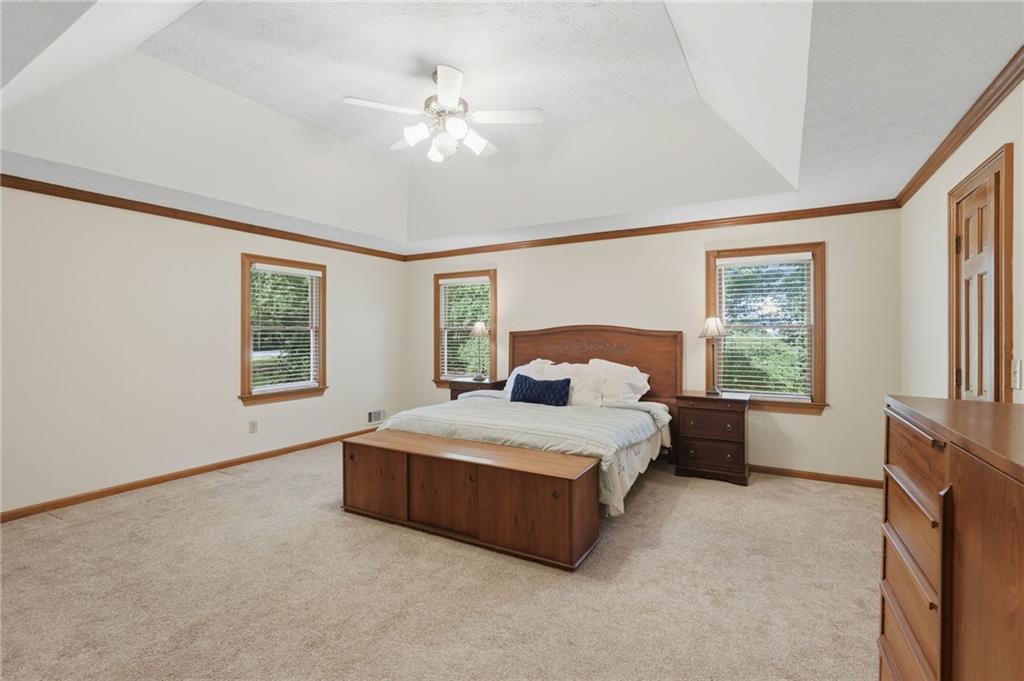 4891 Bill Cheek Road Auburn, GA 30011 - Photo 31 of 99 a spacious bedroom with a large bed and a chandelier