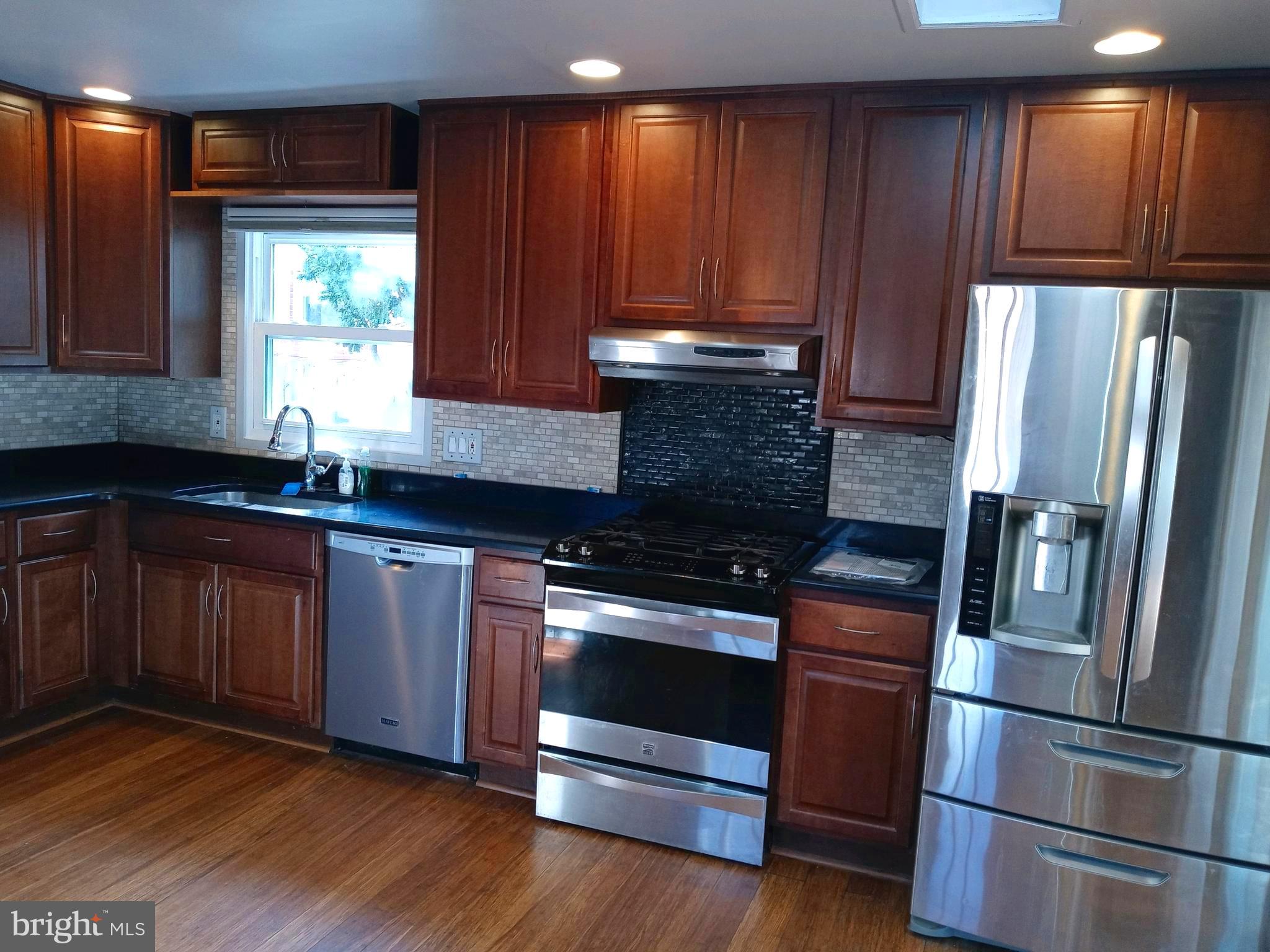 12616 Epping Road Silver Spring, MD 20906 - Photo 5 of 28 a kitchen with granite countertop wooden floors stainless steel appliances and window