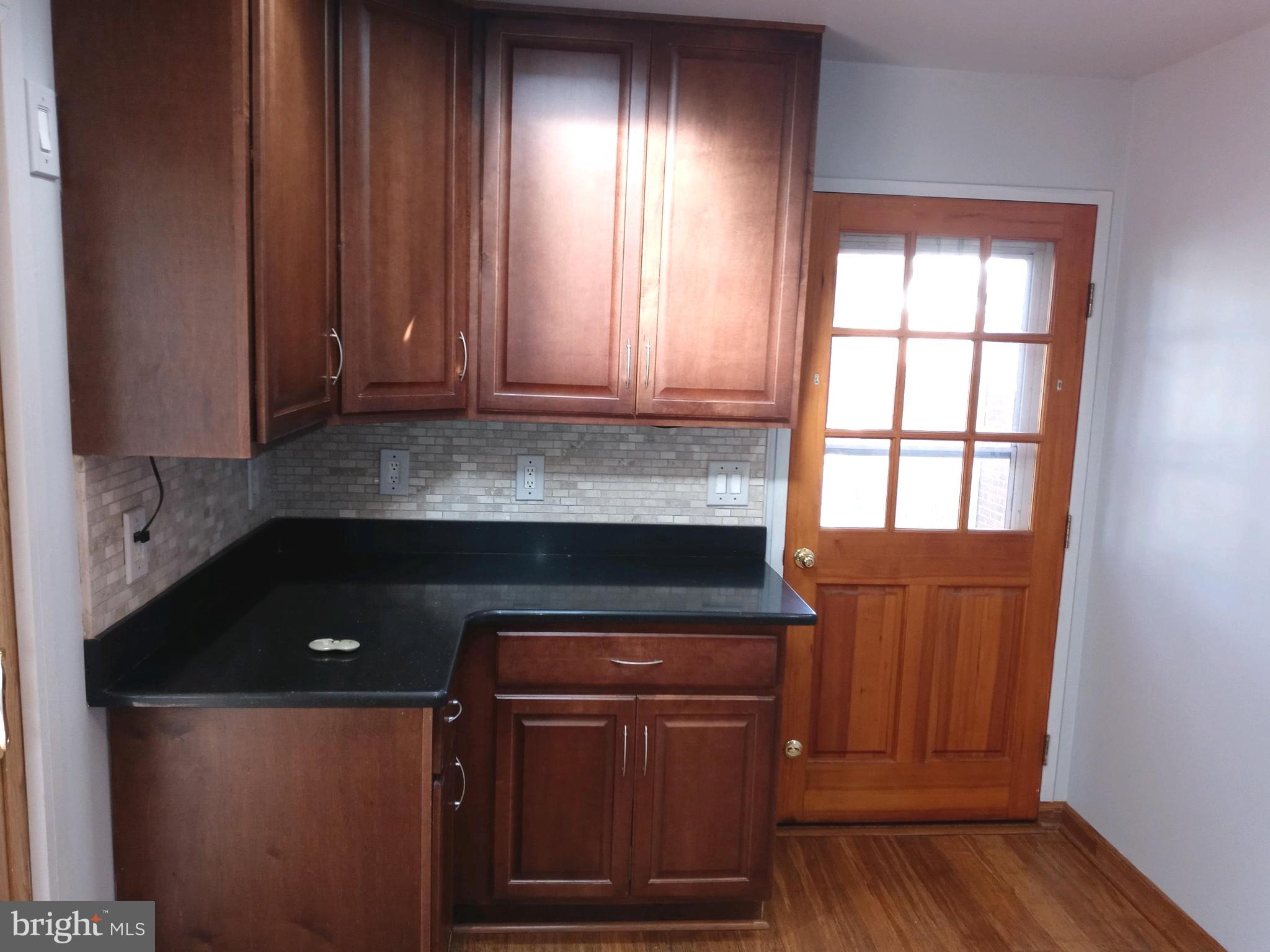 12616 Epping Road Silver Spring, MD 20906 - Photo 7 of 28 a kitchen with granite countertop wooden cabinets and a wooden floor