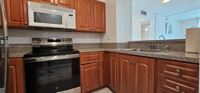 a kitchen with granite countertop cabinets stainless steel appliances and a sink
