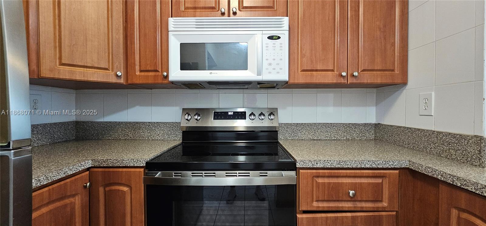 501 Southwest 1st Street, Unit 507 Miami, FL 33130 - Photo 8 of 25 a kitchen with granite countertop a stove top oven cabinetry and garage