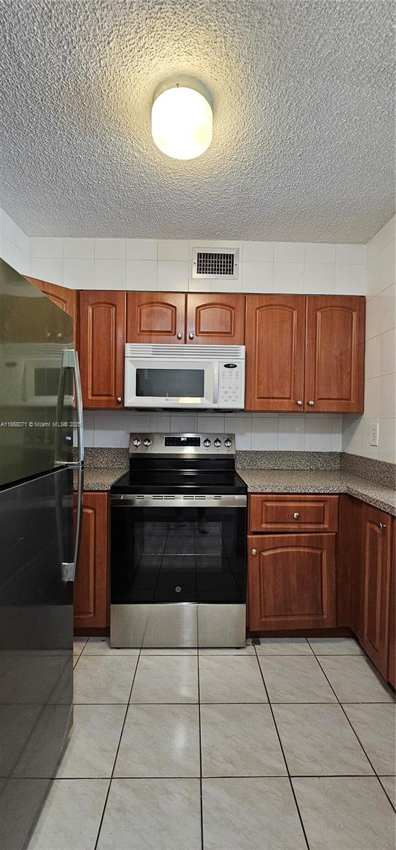 501 Southwest 1st Street, Unit 507 Miami, FL 33130 - Photo 9 of 25 a kitchen with stainless steel appliances granite countertop a stove a sink and a microwave