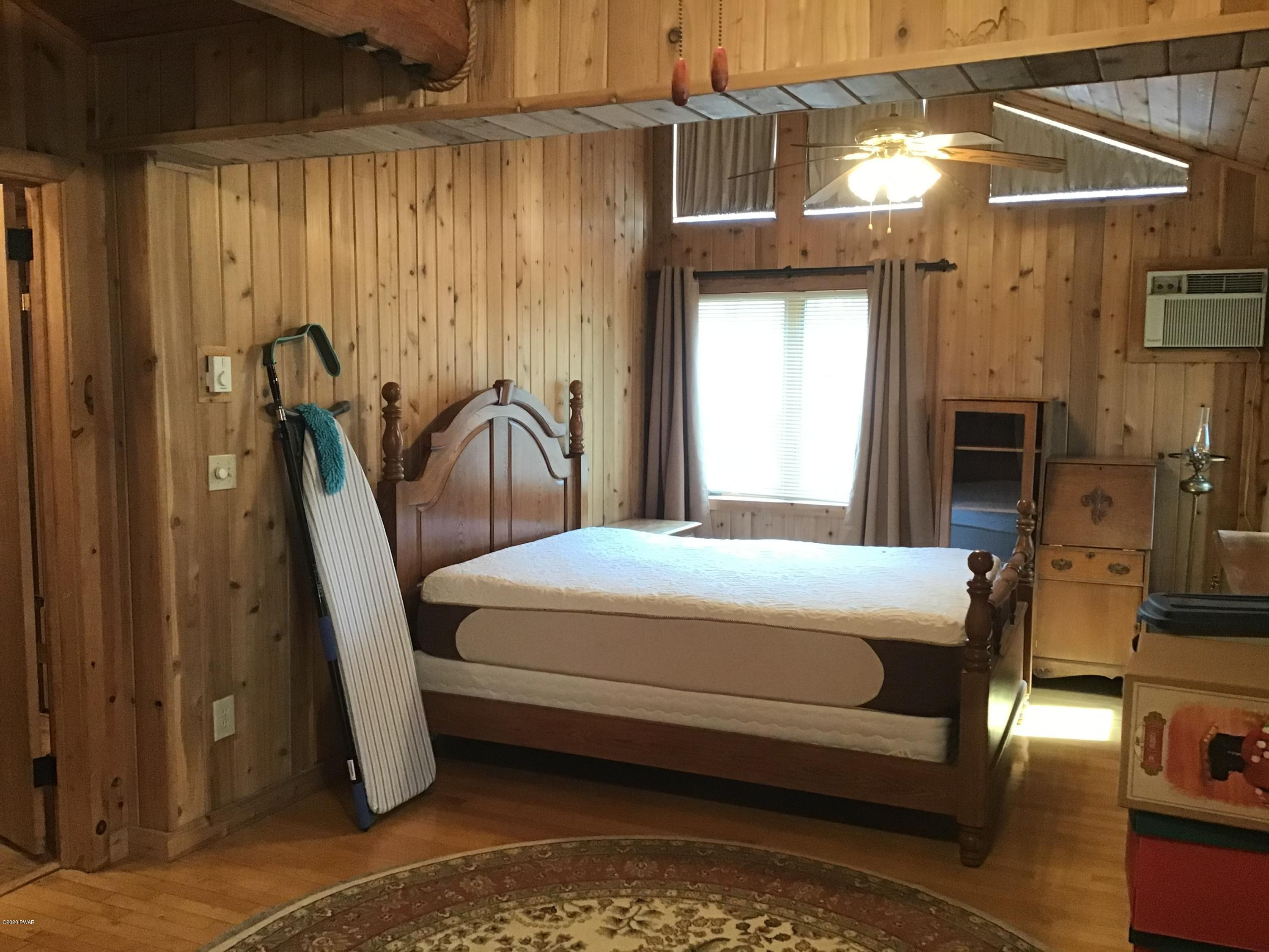 107 Maple Ridge Drive Hawley, PA 18428 - Photo 20 of 32 a bed room with a bed and a chair