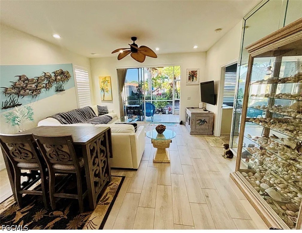 14971 Rivers Edge Court, Unit 101 Fort Myers, FL 33908 - Photo 6 of 15 a living room with furniture a flat screen tv and a large window