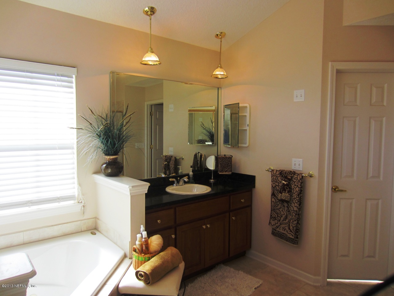 1050 Cactus Cut Road Middleburg, FL 32068 - Photo 31 of 54 a spacious bathroom with a granite countertop sink a mirror and shower