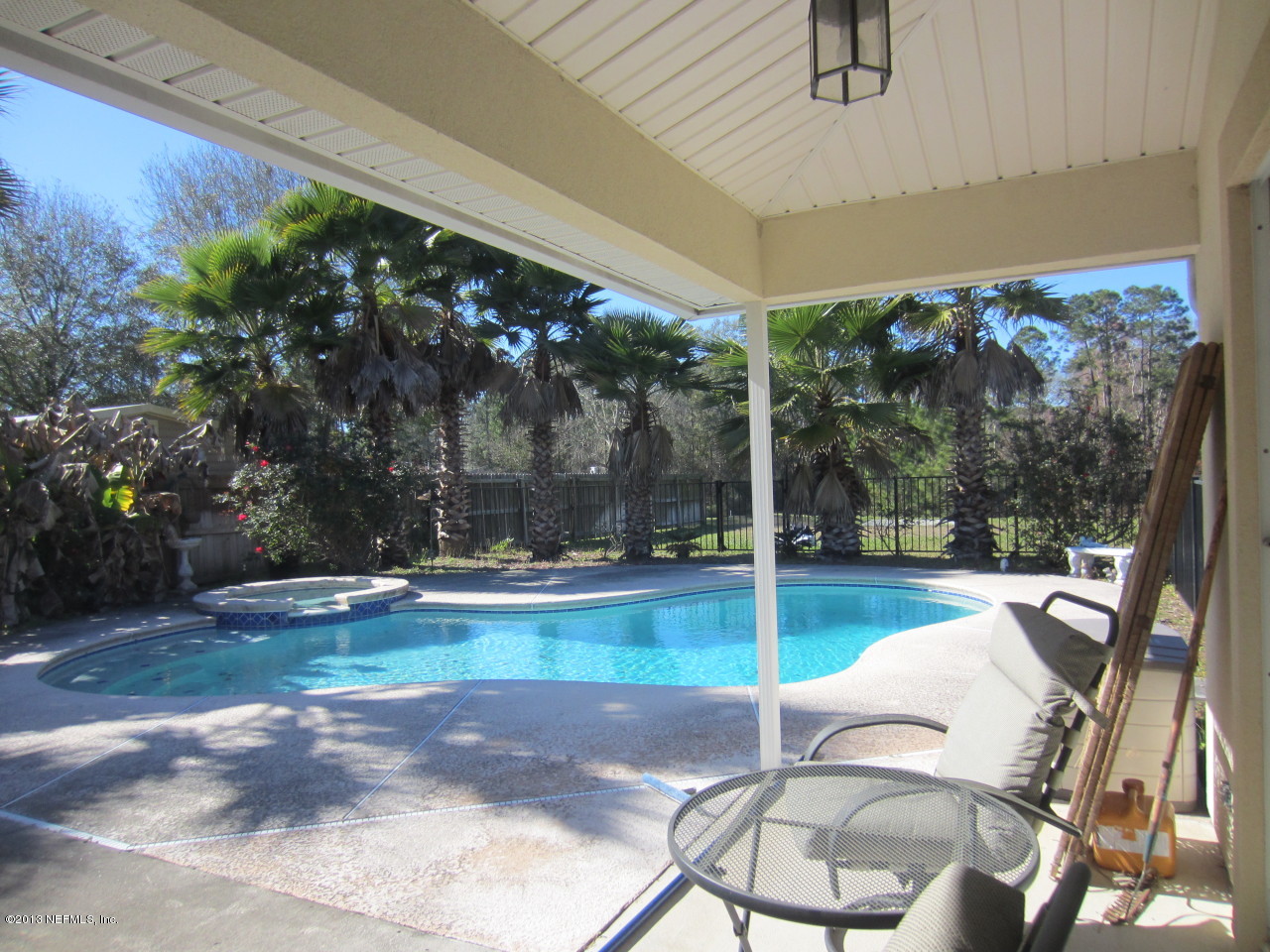 1050 Cactus Cut Road Middleburg, FL 32068 - Photo 7 of 54 a view of a patio with a table chairs potted plants and palm trees