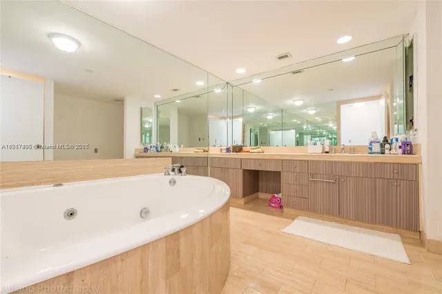 a bathroom with a tub a sink shower and a mirror