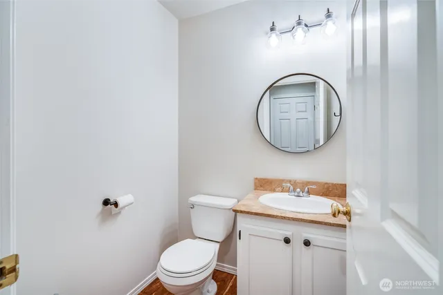 a bathroom with a toilet a sink and mirror