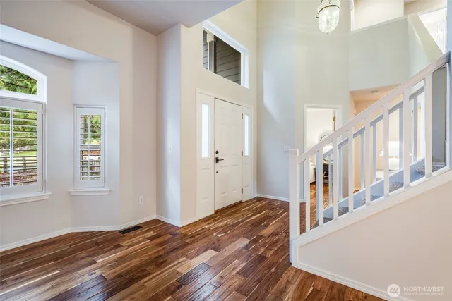 a view of an entryway with wooden floor and staircase