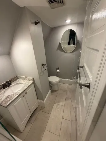 a en suite bathroom with a granite countertop toilet and a sink