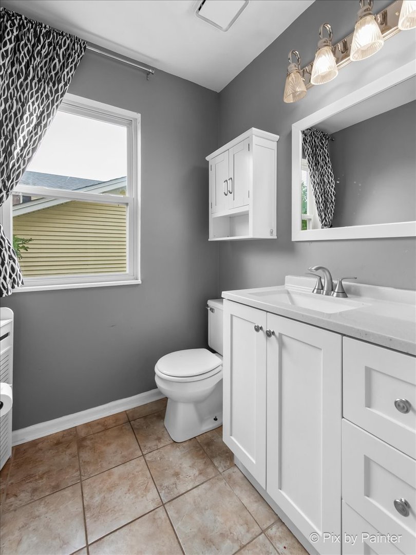 903 Pin Oak Circle Cary, IL 60013 - Photo 17 of 32 a bathroom with a toilet sink vanity and mirror