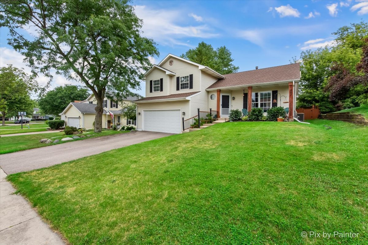 903 Pin Oak Circle Cary, IL 60013 - Photo 26 of 32 a front view of a house with a garden and trees