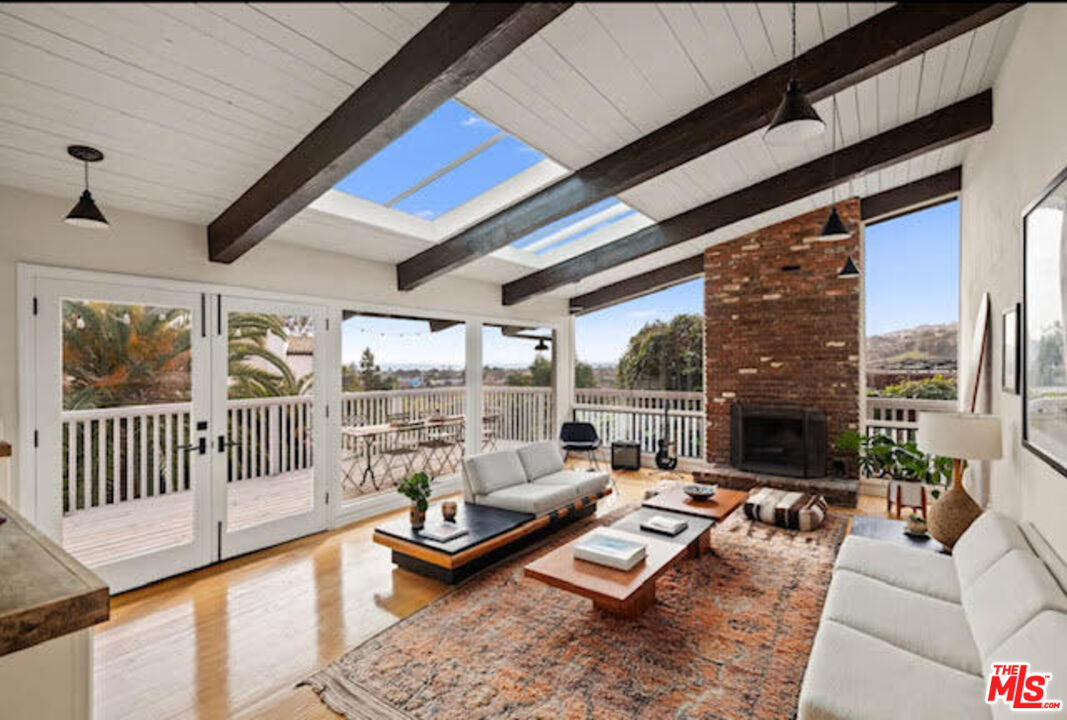 a living room with furniture fireplace and a large window
