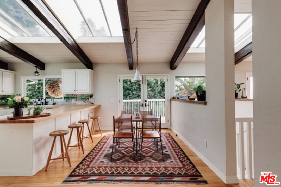 3629 Serra Road Malibu, CA 90265 - Photo 12 of 18 a dining room with wooden floor and a rug