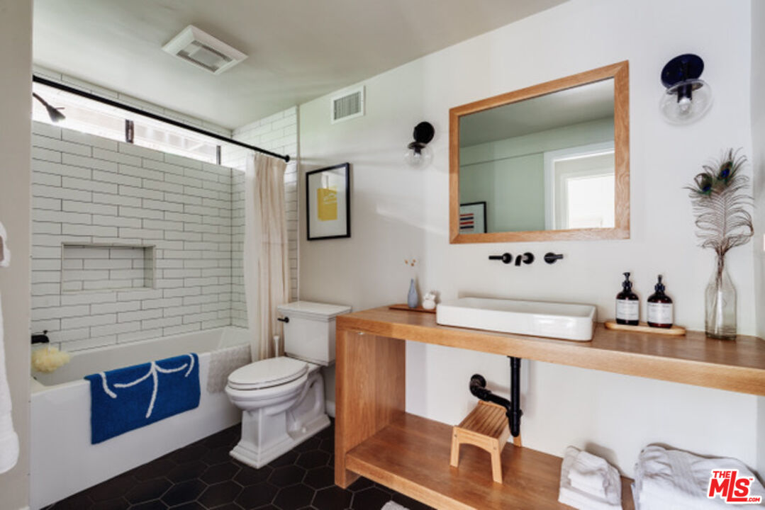 3629 Serra Road Malibu, CA 90265 - Photo 14 of 18 a bathroom with a sink a toilet and mirror