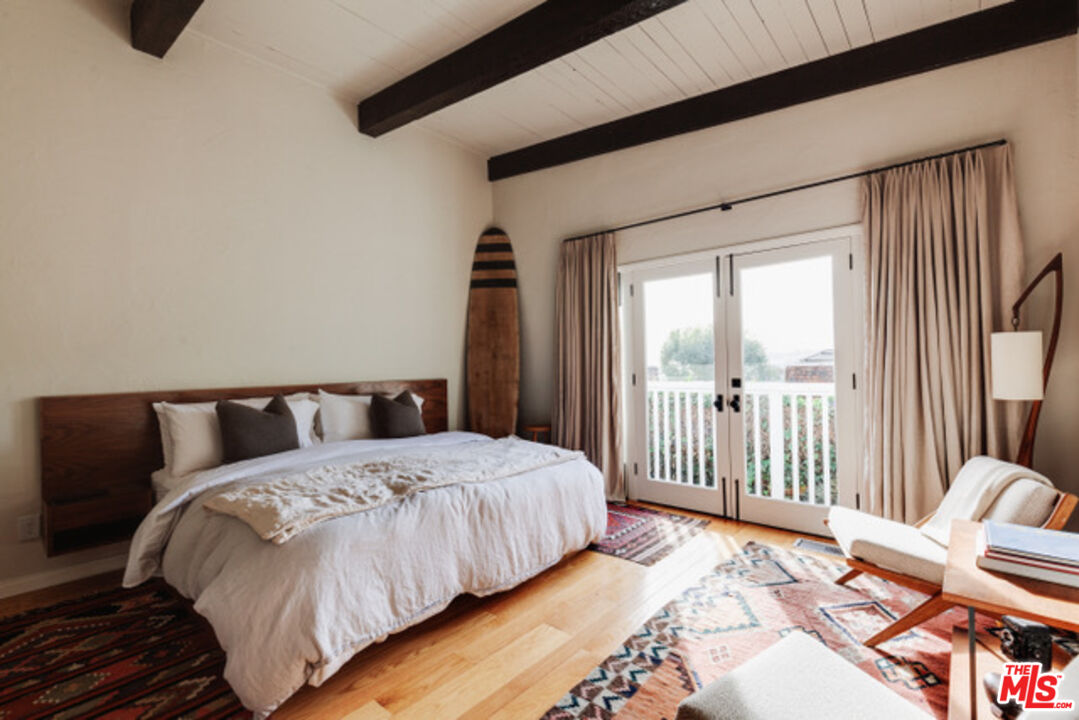 3629 Serra Road Malibu, CA 90265 - Photo 9 of 18 a bedroom with a bed and a chair