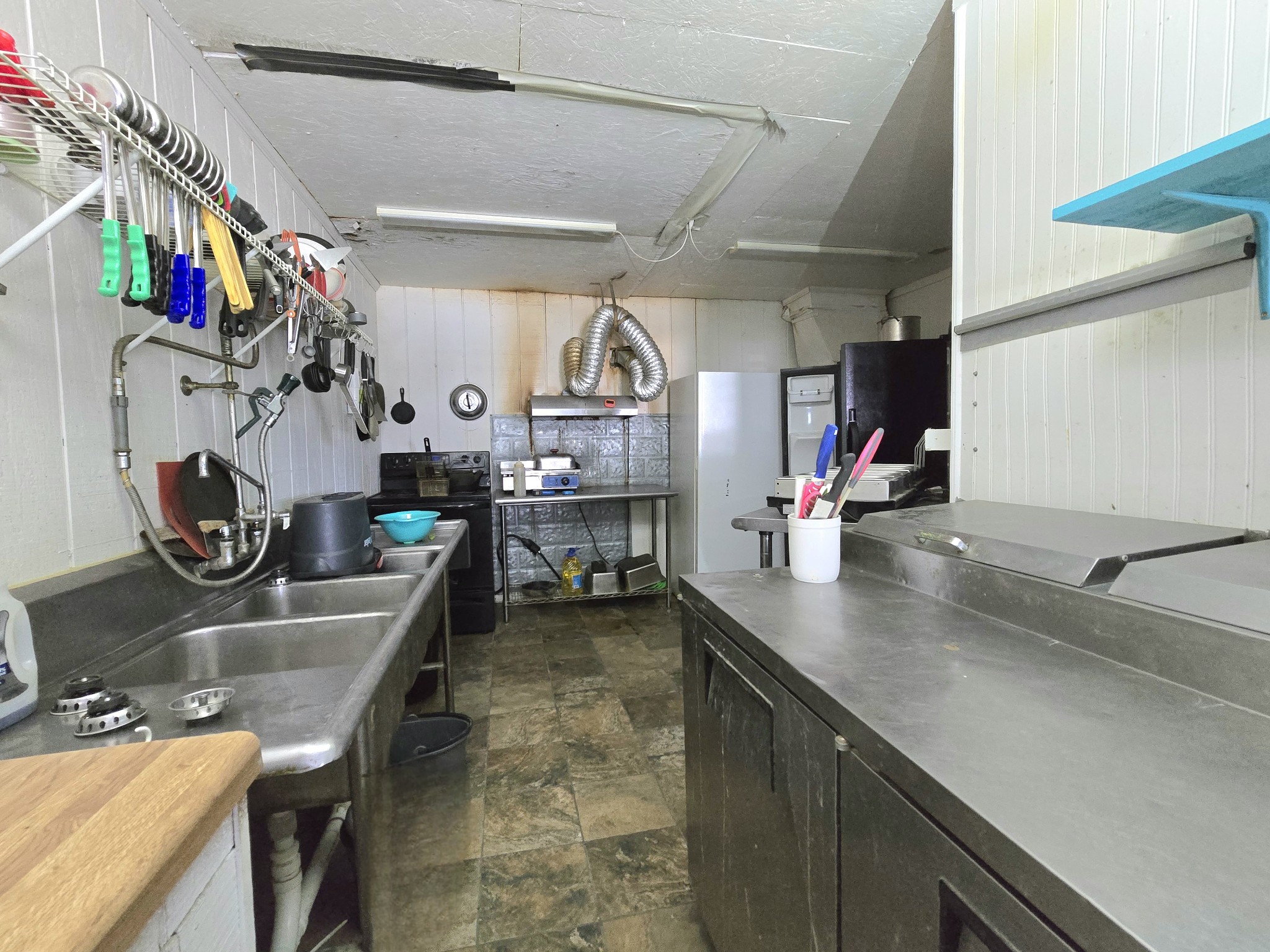 7089 Short Mountain Road McMinnville, TN 37110 - Photo 30 of 36 a kitchen with a sink dishwasher and a stove with wooden floor