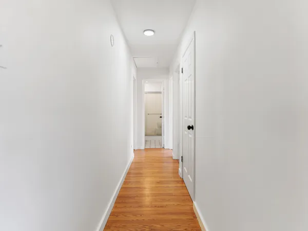 a view of a hallway with wooden floor