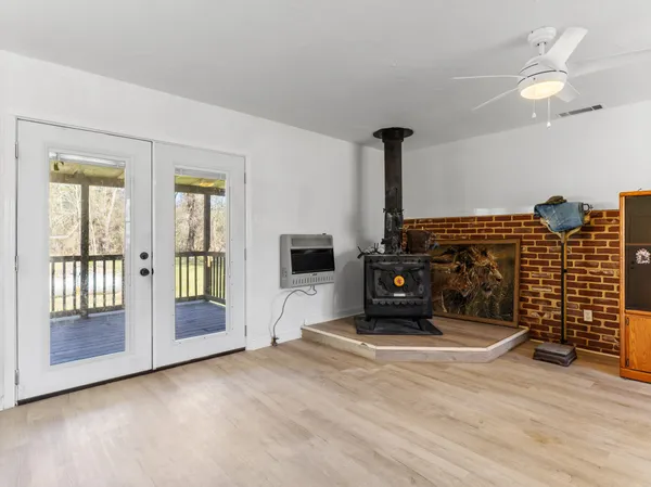 a view of a livingroom with wooden floor and a fireplace